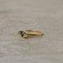 14k gold eye-shaped signet ring, with a flush set heart cut parti sapphire displaying blue and yellow colors