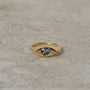 14k gold eye-shaped signet ring, with a flush set heart cut parti sapphire displaying blue and yellow colors
