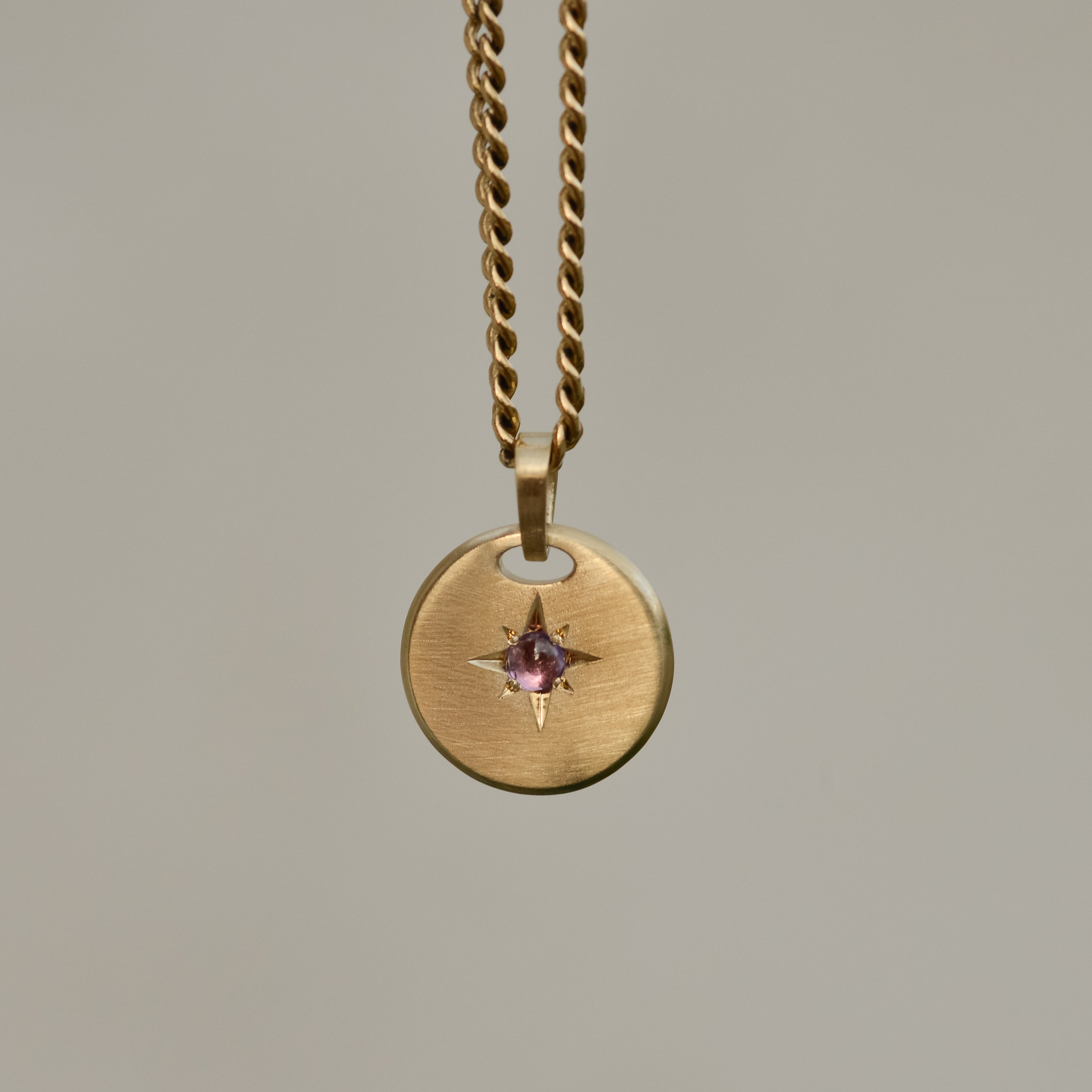 Round star-set charm, sapphire cabochon