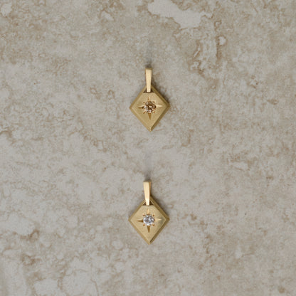 Two lozenge-shaped tag pendants with star set round brilliant cut diamonds, one champagne color, one white