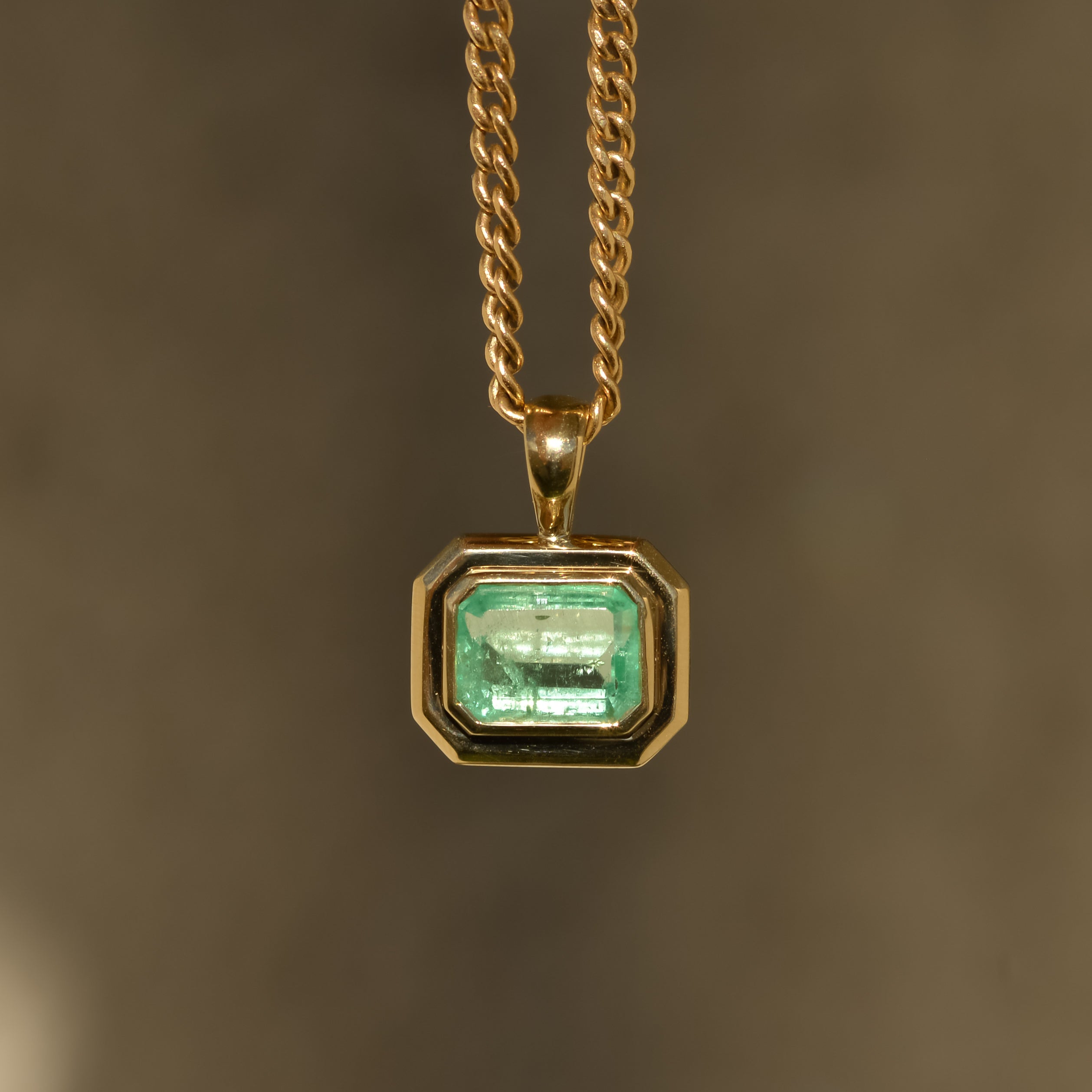 Natural emerald pendant bezel-set in chunky 14k gold 
