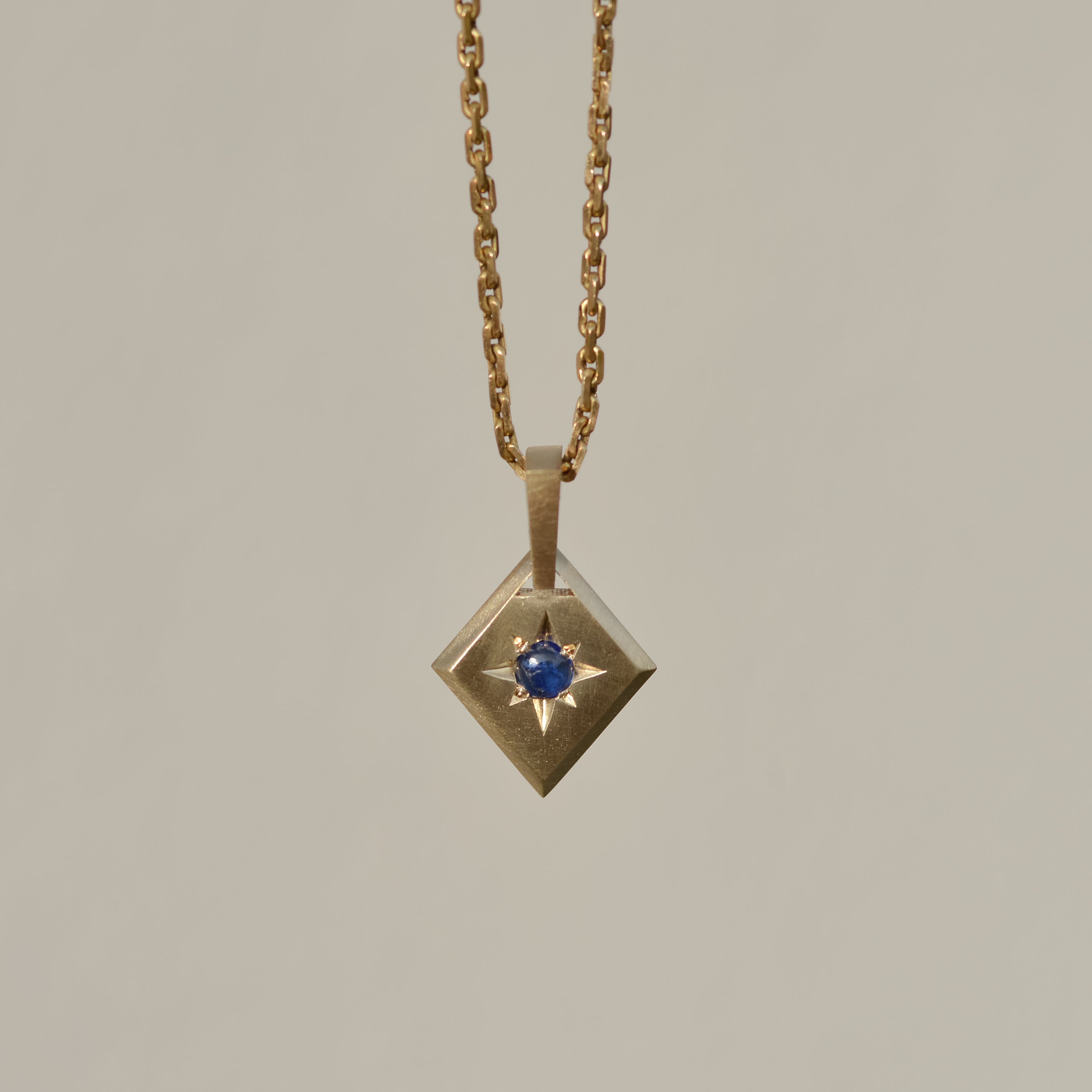 Lozenge Star-set charm, sapphire cabochon