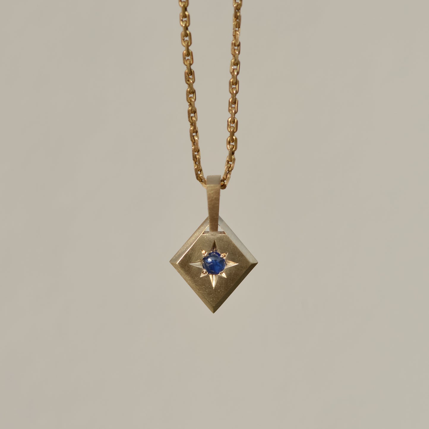 Lozenge Star-set charm, sapphire cabochon