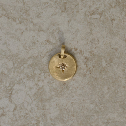 Round-shaped tag pendant with star set champagne round brilliant cut diamond