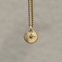 Round-shaped tag pendant with star set champagne round brilliant cut diamond
