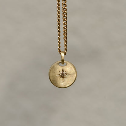 Round-shaped tag pendant with star set champagne round brilliant cut diamond