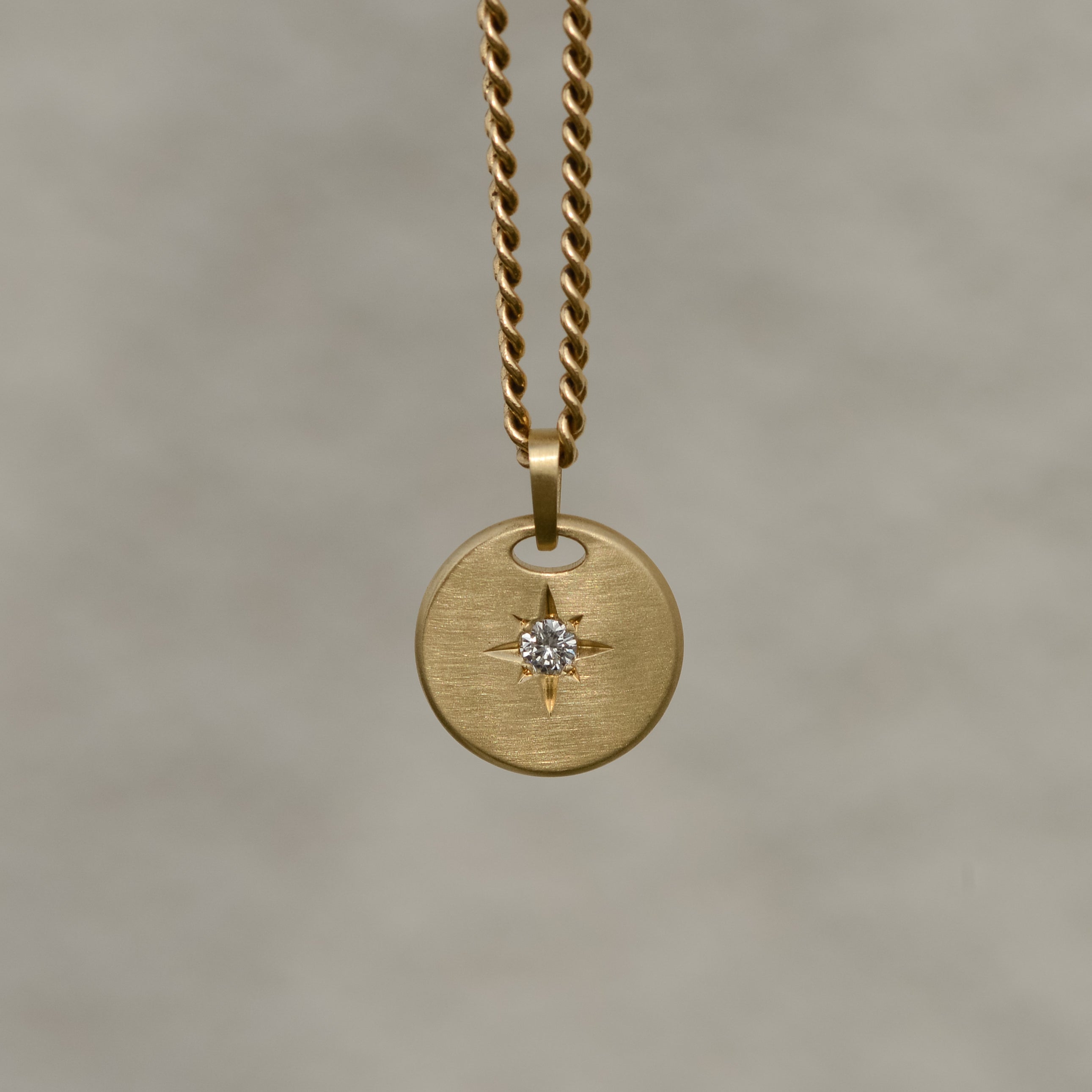 Round-shaped tag pendant with star set white round brilliant cut diamond