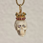Carved bone skull pendant with diamond eyes and 14k gold crown set with diamonds, rubies, emeralds, and sapphires.