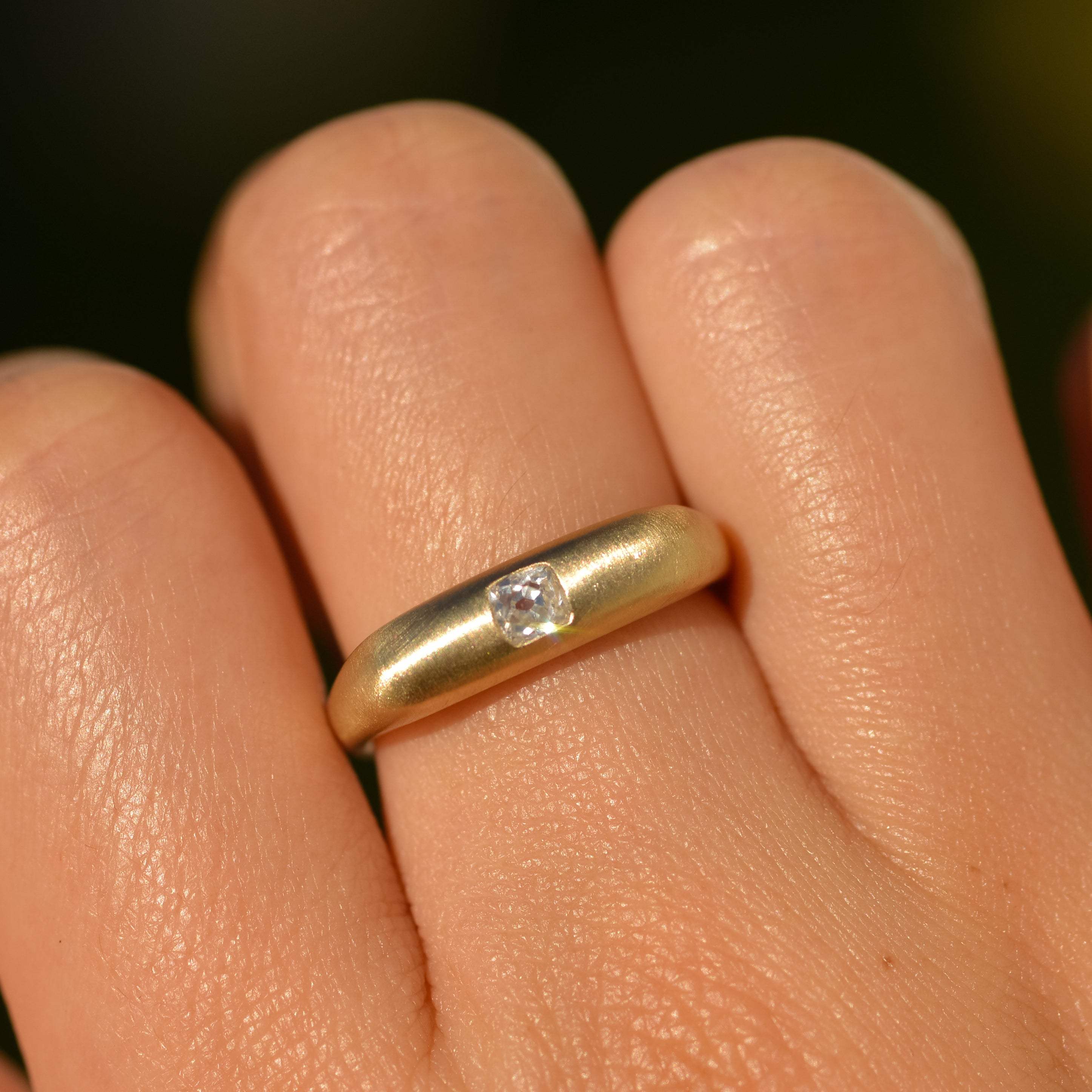 14k gold square band ring with a brushed finish and flush set with a 0.25 carat old mine cut diamond
